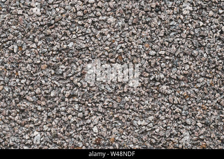 Background of small brown and gray pebbles. Rough stone wall, abstract pattern. Surface, rock texture. Stock Photo