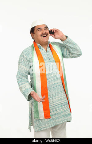 Indian politician talking on mobile phone and laughing Stock Photo