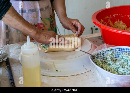Preparing stuffed pita with labaneh and hyssop Stock Photo