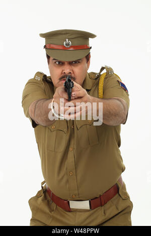 Indian policeman pointing gun Stock Photo