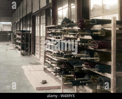 [ 1900s Japan - Paper Umbrellas at Japanese School ] —   Paper umbrellas stacked at an elementary school.  This image is part of 'The School Life of Young Japan' (No 2), a series published by Japanese photographer Kozaburo Tamamura in the early 1900s (late Meiji).  Original text: 'The umbrellas and shoes are placed on racks—'a place for everyhting, and everything in its place' being the order of the day.'  20th century vintage glass slide. Stock Photo