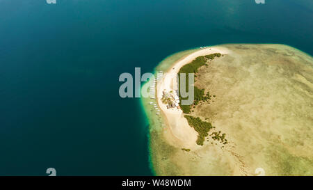 Tropical island and sandy beach with tourists surrounded by coral reef and blue sea in honda bay, aerial view. Island with sand bar and coral reef. starfish island. Summer and travel vacation concept, Philippines, Palawan Stock Photo