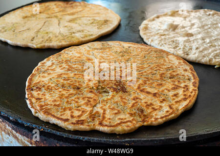 Stuffed pita with potatoes on a heated taboon Stock Photo