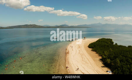 Tropical island and sandy beach with tourists surrounded by coral reef and blue sea in honda bay, aerial view. Island with sand bar and coral reef. starfish island. Summer and travel vacation concept, Philippines, Palawan Stock Photo