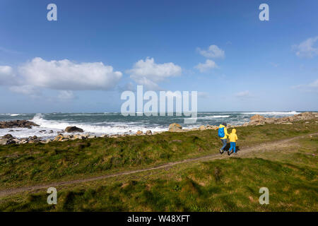 Mother and son walking on footpath in the rugged coastal landscape in Brittany, France Stock Photo