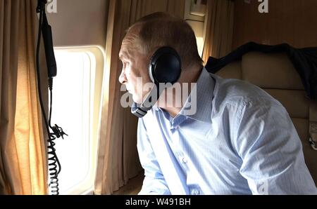 Russian President Vladimir Putin looks out from his helicopter at flood damage to homes caused by massive floods in the Irkutsk region July 19, 2019 in Tulun, Irkutsk, Russia. The flooding in eastern Siberia is the worst in the recorded history of the region effecting 3,800 homes. Stock Photo