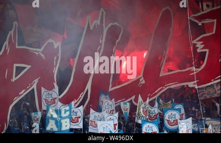 Rostock, Germany. 20th July, 2019. Soccer: 3rd league, 1st matchday, FC Hansa Rostock - Viktoria Köln in the Ostseestadion: At the start of the match, Hansa fans wave blue and white Hansa flags on the south stand and burn down pyrotechnics. Credit: Bernd Wüstneck/dpa-Zentralbild/dpa/Alamy Live News Stock Photo