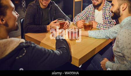 Beer friends free time concept. Cheerful friends with glasses and beer in the bar. Stock Photo
