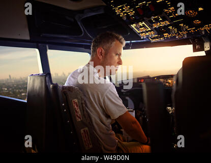 experienced young pilot in the cockpit of the plane Stock Photo