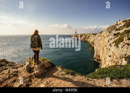 Female hiker standing on edge of rocky cliff Stock Photo