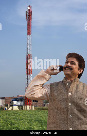 Farmer talking on mobile phone in a field Stock Photo