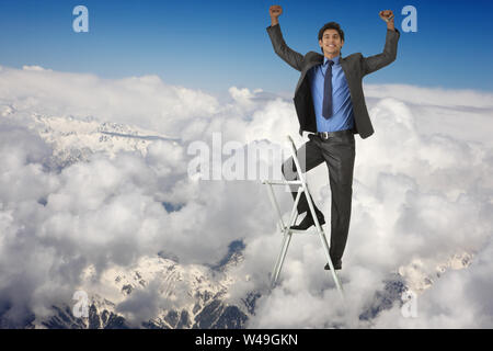 Businessman standing on step ladder and smiling Stock Photo