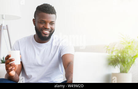 Young man using laptop, having video chat Stock Photo