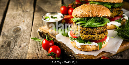 Vegan zucchini burger and ingredients on rustic wood background Stock Photo