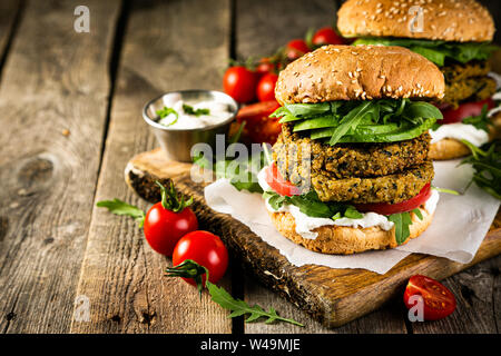 Vegan zucchini burger and ingredients on rustic wood background Stock Photo