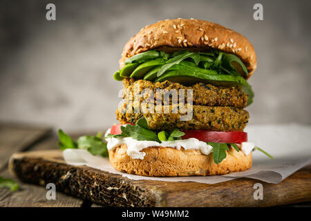 Vegan zucchini burger and ingredients on rustic wood background Stock Photo