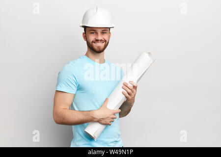 Successful handsome architect is standing and holding a blueprint in his hands.man with new ideas, creative plan of building an office. isolated white Stock Photo