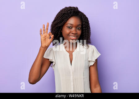 smiling pretty afro female with wavy curly hair businesswoman making ok sign, everything is ok. body language Stock Photo