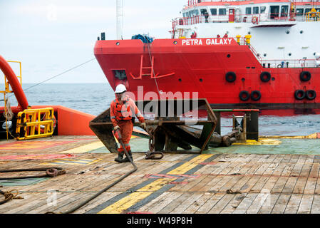 marine crew doing offshore anchor job handling operation for work boat Stock Photo