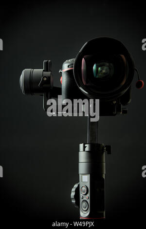Close-up of gimbal stabilizer, and dsl camera with low-key lighting and a black background Stock Photo