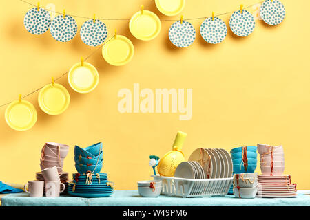 pile of unwashed cutlery on the table. close up photo. and clean plaets hanging above them Stock Photo