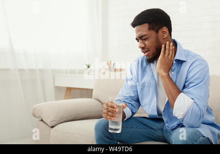 Frustrated young african-american man touching his neck Stock Photo
