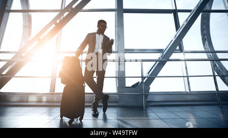 Confident Businessman Waiting for Flight in Airport Terminal Stock Photo