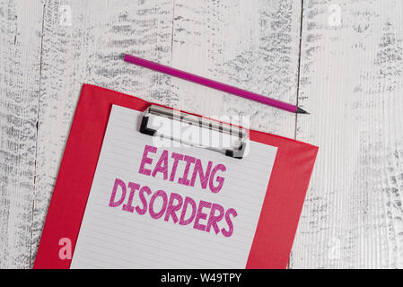 Handwriting text Eating Disorders. Conceptual photo any of a range of psychological abnormal food habits Colored clipboard blank paper sheet pencil ol Stock Photo