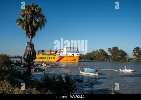 Passage of a cargo ship departed from Sevilla port and navigating Guadalquivir river to the Ocean. Coria del Rio, Andalucia, July 2019 Stock Photo