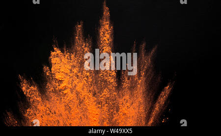 Abstract colored dust explosion of orange holi on black Stock Photo
