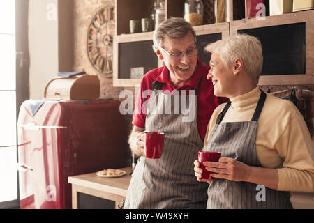 Senior man and woman having nice morning talk with coffee in kitchen Stock Photo
