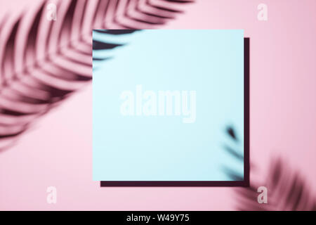 Creative layout made of Shadow of a palm frond on a pink pastell wall with central blank square canvas or picture frame in an interior design template Stock Photo