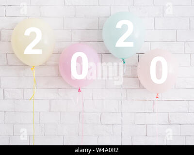 Funny colorful balloons with white numbers on bricks wall Stock Photo
