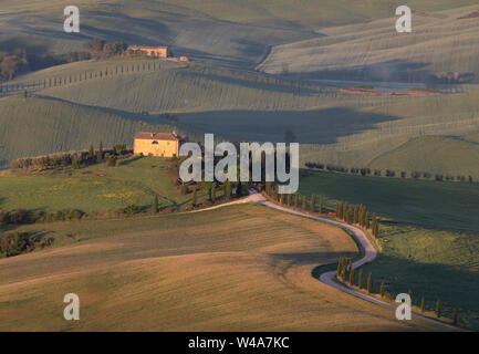 Traditional agriturismo villa in the valley of Val d'Orcia in Tuscany at sunrise. Pienza, Italy. Stock Photo