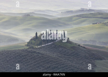 Famous villa Podere in Val d'Orcia during foggy sunrise in Tuscany. Pienza, Italy. Stock Photo