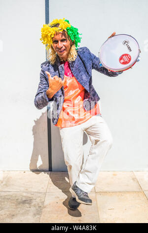 Oeiras, Brazil - Circa July 2019: Street artist with a wig and a tambourine in the center of Oeiras, Piaui Stock Photo
