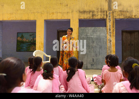 Female teacher teaching students in a class Stock Photo