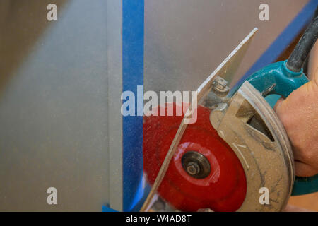 Contractor using electric saw to cut cabinet repairman working in the kitchen Stock Photo