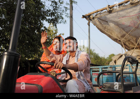 Farmer driving a tractor with his wife sitting beside him Stock Photo ...
