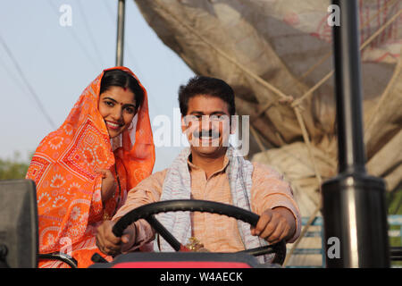 Farmer driving a tractor with his wife sitting beside him Stock Photo ...