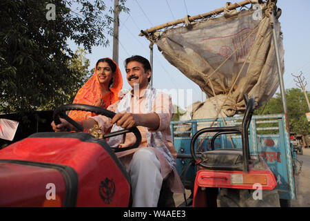 Farmer driving a tractor with his wife sitting beside him Stock Photo ...