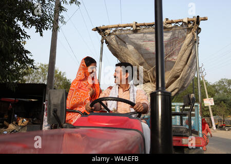 Farmer driving a tractor with his wife sitting beside him Stock Photo ...