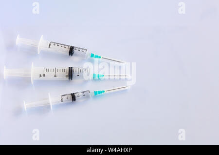 Three syringes of different capacity on the belm table in the hospital, prepared for injection, copyspace for text. Stock Photo