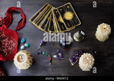 Still life with the tarot cards, magic stones and candles on wooden table. Fortune telling seance or magic ritual. Stock Photo