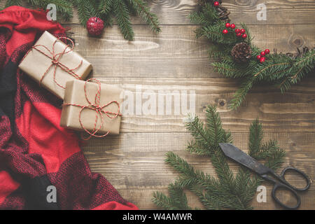 Christmas composition of wreath , checkered pleid, cup of coffee on wooden board. Flat lay. Top view. Copy space. Stock Photo