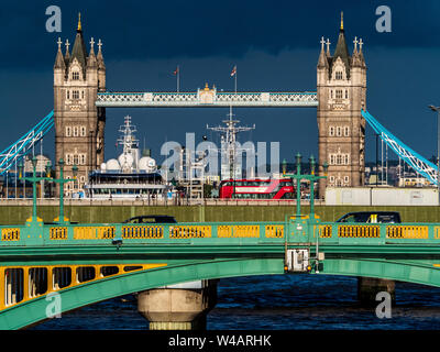 Tower Bridge London under stormy sky. Iconic Tower Bridge against a dark sky with Southwark Bridge and London Bridge traffic visible in the foreground Stock Photo