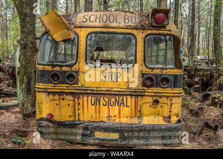 White, Georgia/USA-3/28/18 An old vintage school bus back view close up left to decay in a junkyard on a sunny day Stock Photo