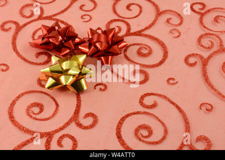 Close up of red and gold Christmas bows on red Christmas gift Stock Photo