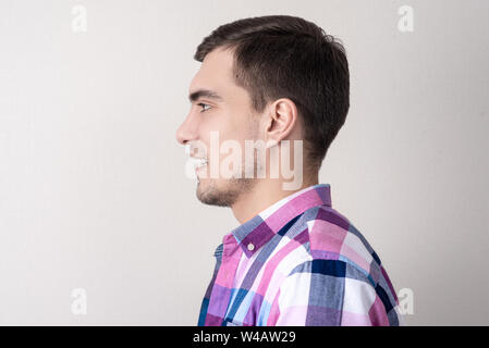 Portrait in profile of young European man isolated on gray background Stock Photo