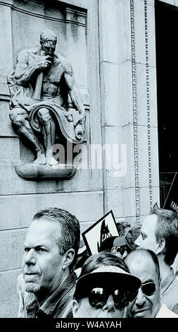 Carved wall statue overlooking resistance marchers Stock Photo
